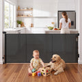 Black Keezi retractable baby and pet safety gate extended to 400cm, showing its mesh design and secure locking mechanism.