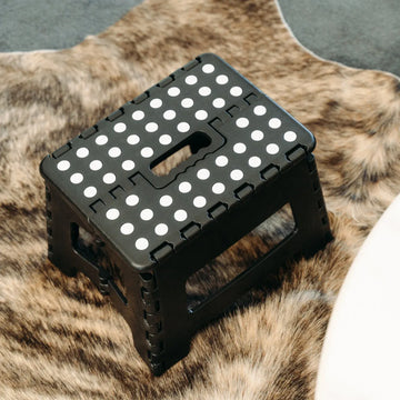 Black portable foldable plastic stool for kids and adults, suitable for outdoor, bathroom, and kitchen use with Everything Baby branding.