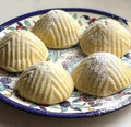 Plastic mooncake mold for dates, nuts, and chocolate, designed for baking and pretend play in a kitchen setting.