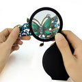 Black folding pocket magnifier loupe with rotating leather holster, 70mm size, ideal for reading, science, and hobbies.