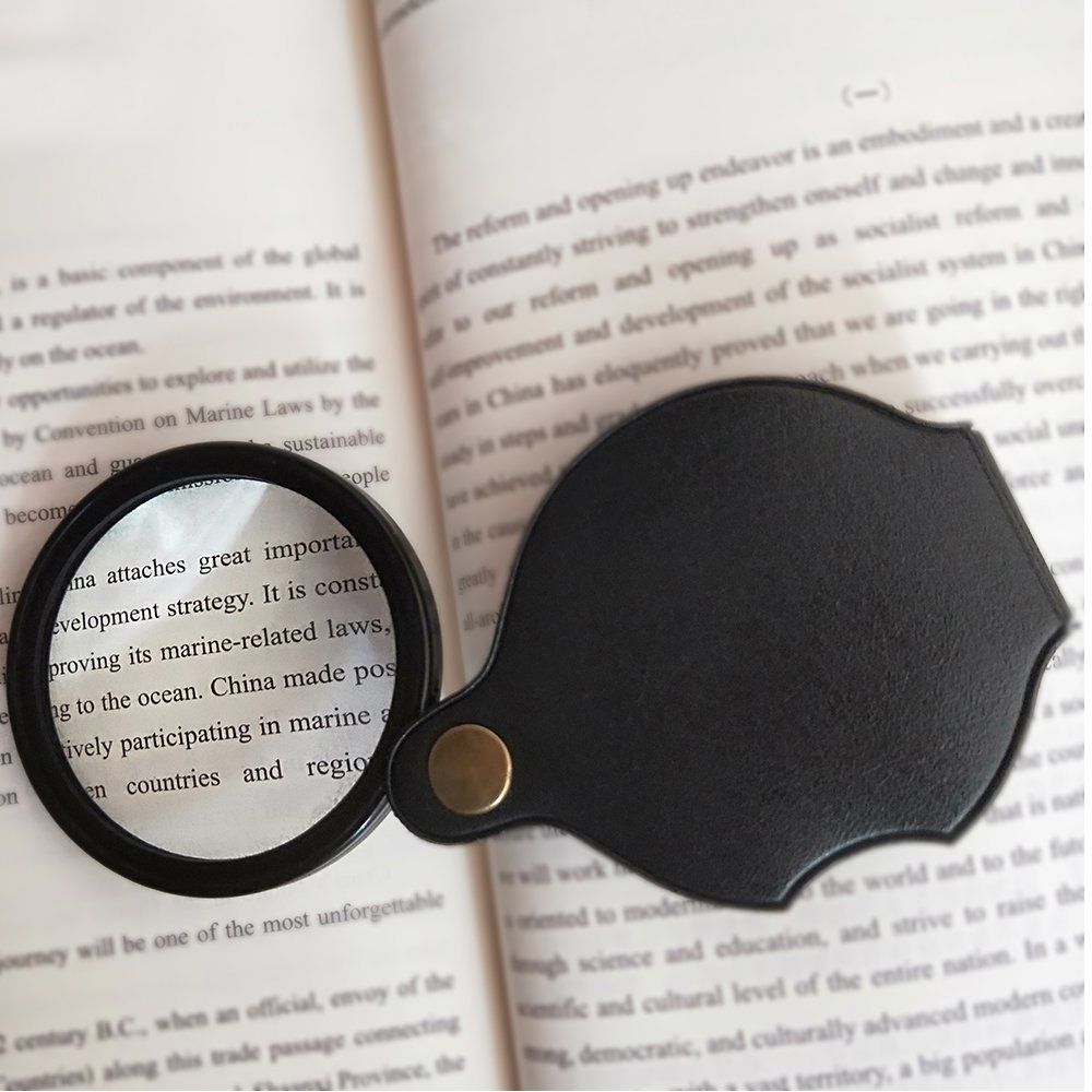 Black folding pocket magnifier loupe with rotating leather pouch, 70mm/2.4" lens, for reading, science, and hobbies.