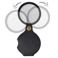 Black folding pocket magnifier loupe with rotating leather pouch, 70mm size, ideal for reading, science, and hobbies.