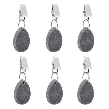 Six teardrop-shaped tablecloth weight pendants with metal clips from Everything Baby, used to secure table covers during family meals.