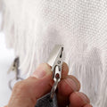 Six teardrop-shaped tablecloth weight pendants with metal clips, designed to secure table covers during family gatherings.
