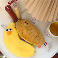 Two cute, soft padded cartoon food-themed pencil cases shaped like a chicken leg and banana, with zipper closures.