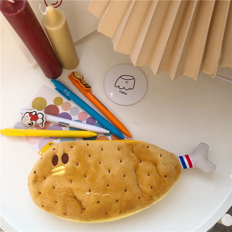 Two soft padded zipper pencil cases shaped like cute chicken leg and banana, featuring funny face designs, ideal for kids.