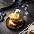Mini glass dessert dome with base, decorative cake tray for displaying small treats or fruits in a kitchen setting.