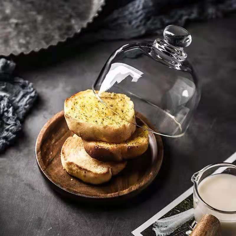 Mini glass dessert dome with base, decorative cake tray for displaying small treats or fruits in a kitchen setting.