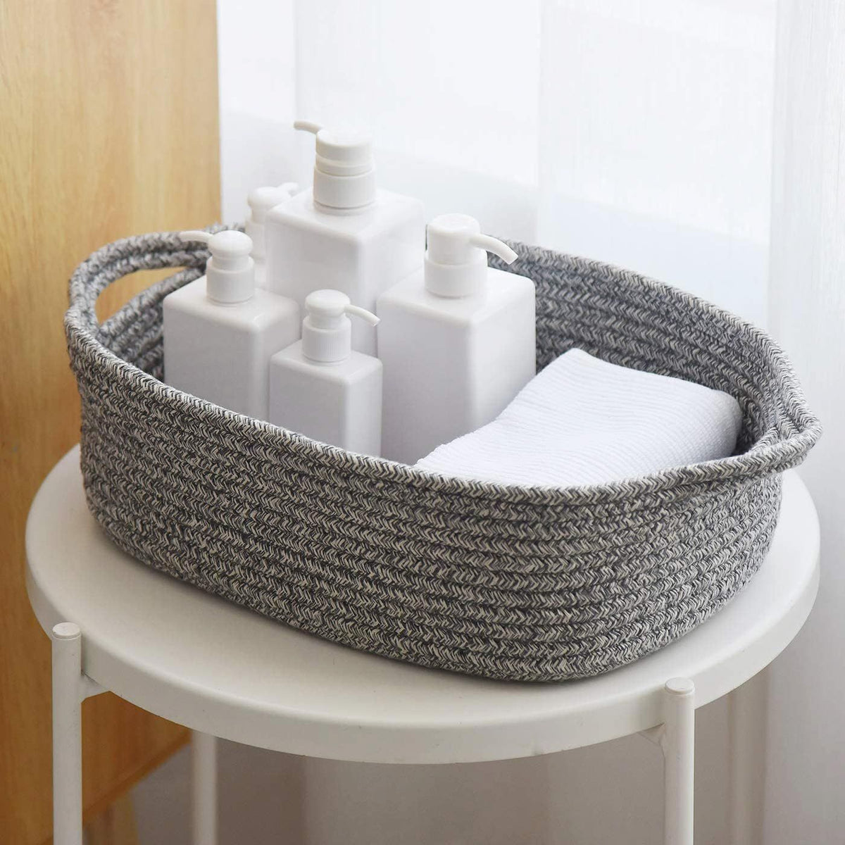Woven cotton rope storage basket by Everything Baby holding nursery towels and toys, cube-shaped for kids' and baby room organization.