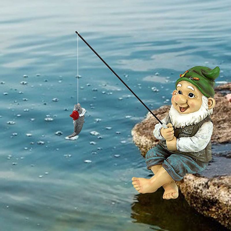 Garden gnome statue sitting outdoors, holding a fishing rod, decorative garden ornament by Everything Baby for outdoor garden decor.