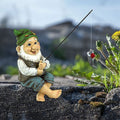 Baby gnome garden fishing statue sitting outdoors, crafted as a decorative fishing-themed garden ornament.