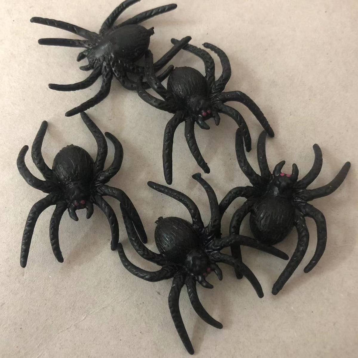 Set of 10 realistic black plastic fake spiders for Halloween decorations and pretend play, perfect for spooky kids' toy props.