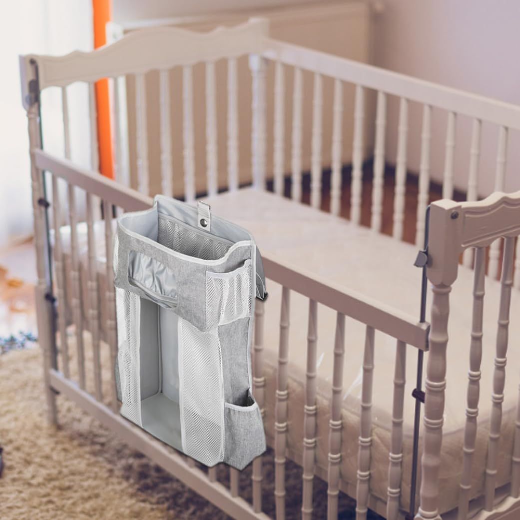 Everything Baby hanging diaper organizer with multiple compartments for baby essentials on a nursery changing table or crib.