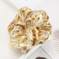 Six gold metallic lame leaf hair scrunchies for girls, shiny elastic ponytail holders, perfect for dance, gym, or party wear.