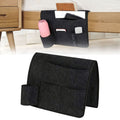 Dark gray bedside caddy organizer with four pockets hanging on a bed, made of durable fabric for dorms, beds, or sofas.