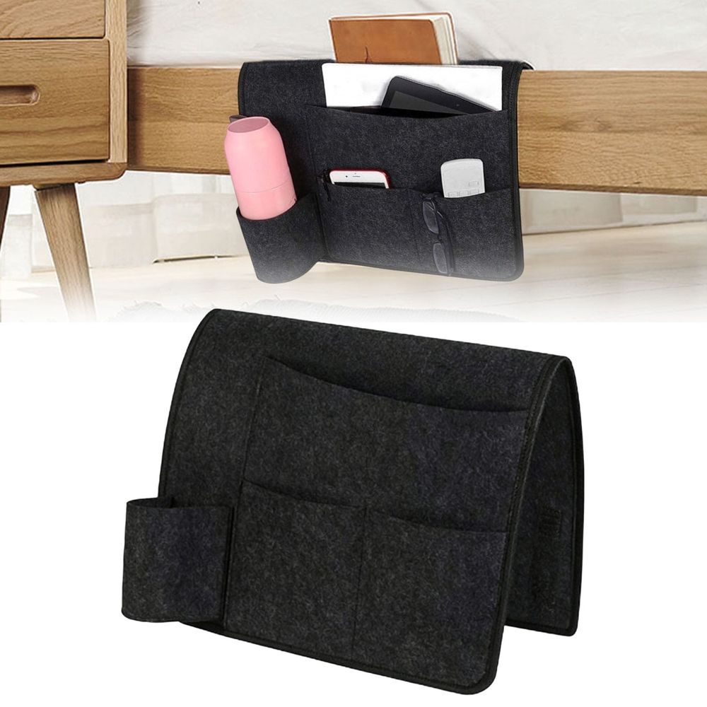 Dark gray bedside caddy organizer with four pockets hanging on a bed, made of durable fabric for dorms, beds, or sofas.
