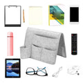Dark gray bedside caddy organizer with four pockets hanging on bed or sofa, made of durable fabric, ideal for dorms and home use