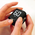 Black bucket timer with rotating dial, showing 5, 10, 30, 60-minute options and custom countdown on a changing table.