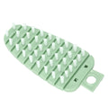 Green carrot-shaped vegetable brush for scrubbing potatoes and fruits, suitable for kitchen cleaning and food prep.