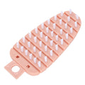 Pink carrot-shaped vegetable brush with soft bristles for cleaning potatoes, fruits, and vegetables in the kitchen.