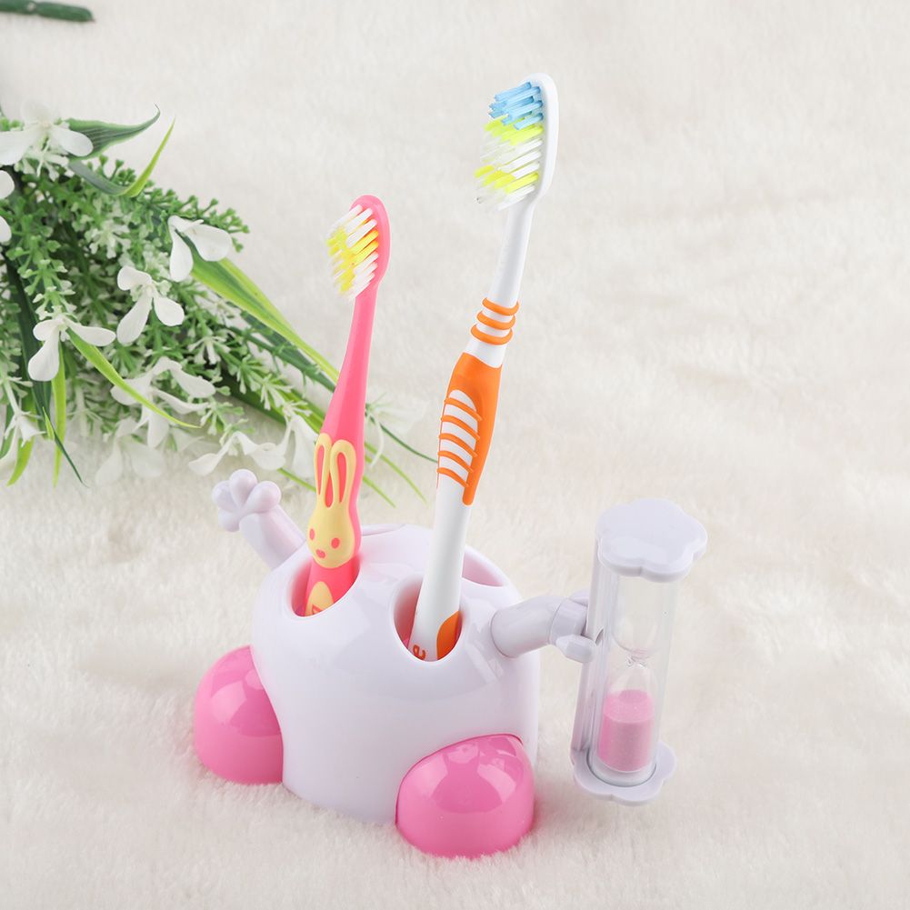 Pink children's toothbrush holder with hourglass timer for 3-minute countdown, part of baby and kids grooming kit.