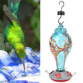 Colorful glass bird feeder with hummingbird design, outdoor garden water feeding tool, suitable for birdwatching and garden decor.