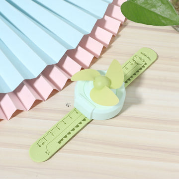 Green cartoon-shaped mini wrist fan for kids with adjustable strap, USB charge, designed for children’s outdoor comfort.