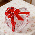 Glass heart-shaped candy jar with lid and red bow, serving dish for snacks or jewelry, from Everything Baby.