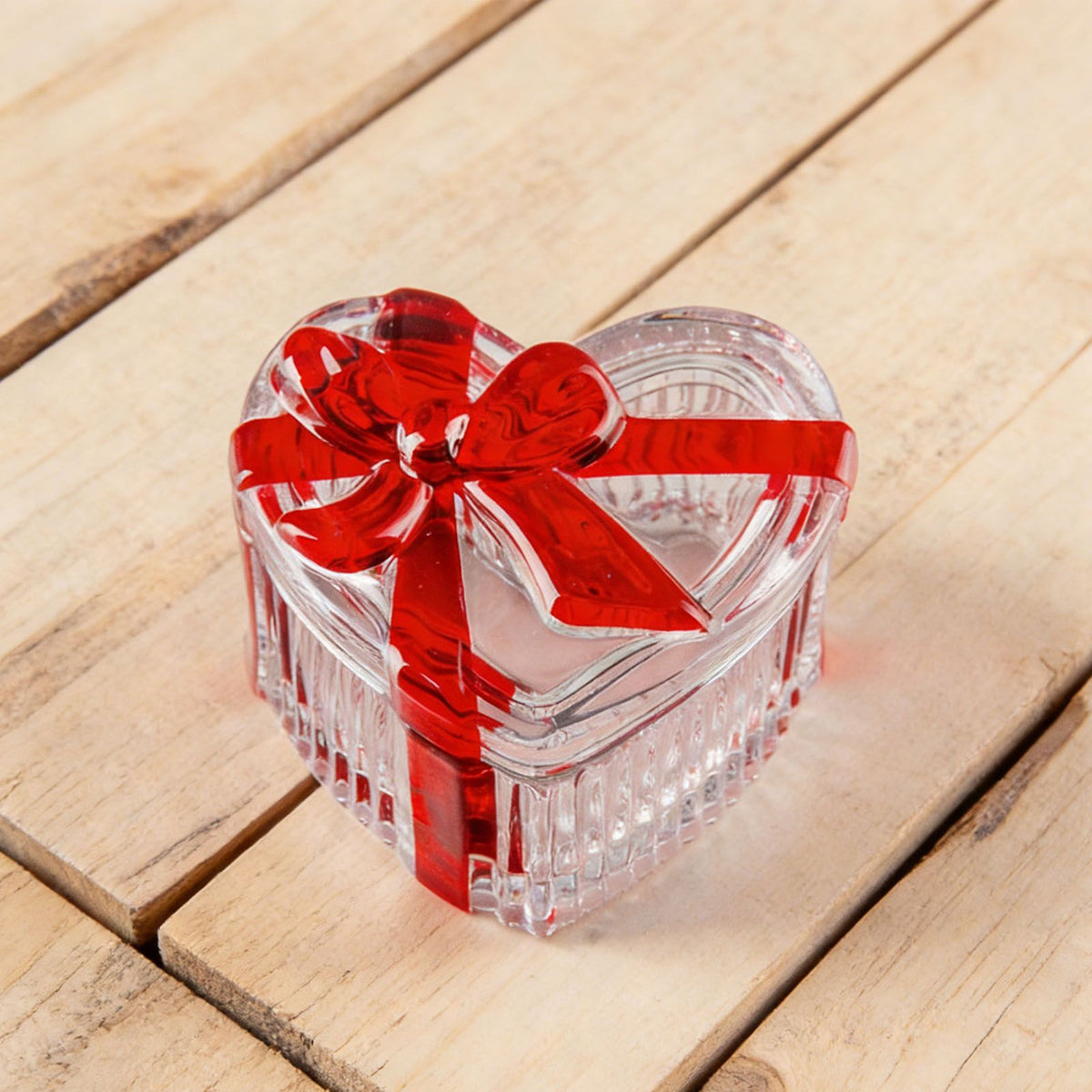 Clear glass heart-shaped candy jar with lid, red bow, ideal for snacks, jewelry, and candy storage in a charming nursery setting.