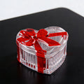 Clear glass heart-shaped candy jar with lid and red bow, ideal for storing snacks, jewelry, or small items.