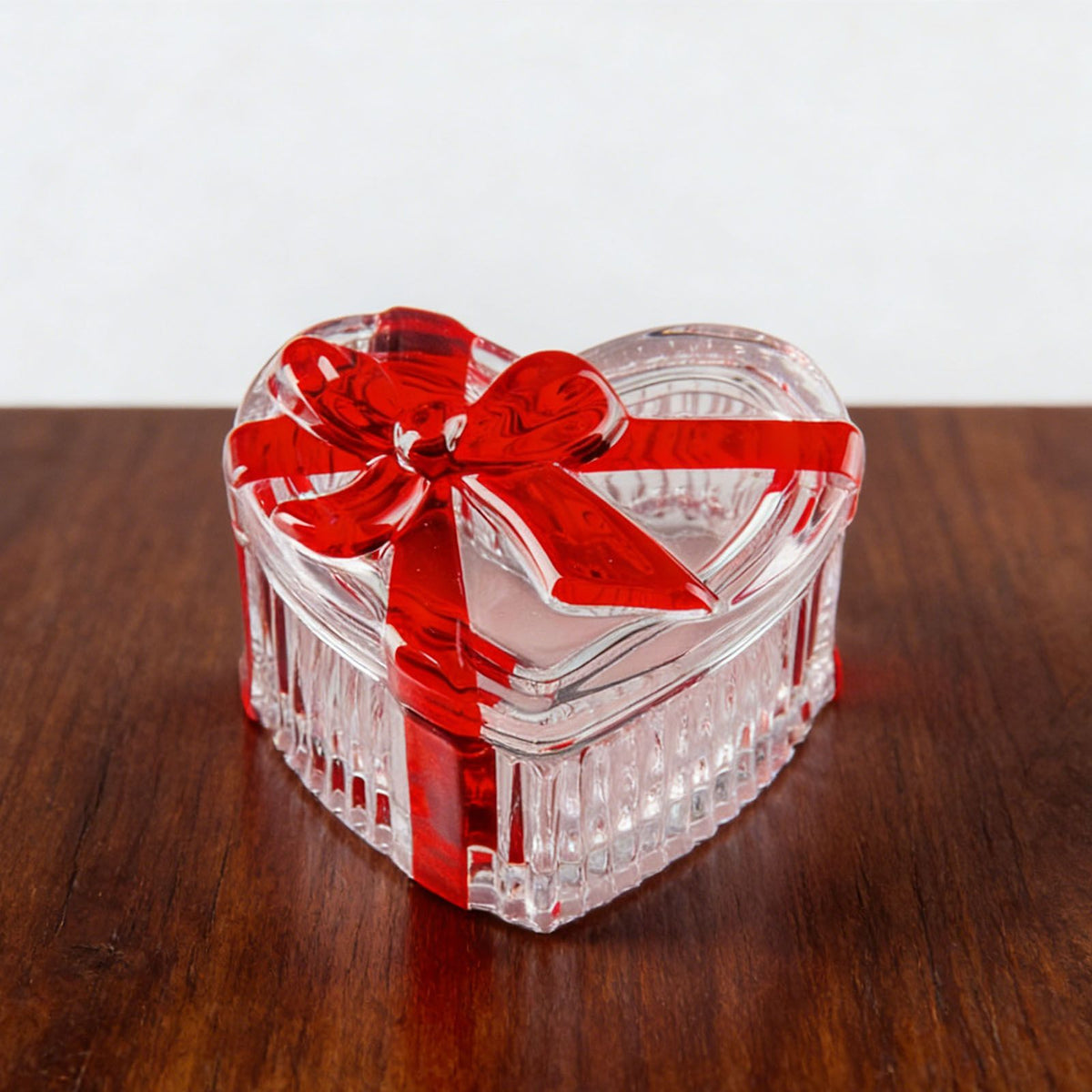 Clear glass heart-shaped candy jar with lid and red bow, perfect for storing snacks, jewelry, or candies.