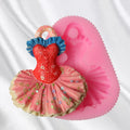 Silicone mold shaped like a baby dress for cake decorating, used for baking and sugar paste in pretend play and food crafting.