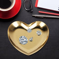 Gold stainless steel heart-shaped tray with compartments, used as a jewelry organizer and serving tray for tea, fruit, or cosmetics.