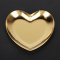 Gold stainless steel heart-shaped tray used as a tea tray, fruit tray, or jewelry organizer, ideal for home or nursery decor.