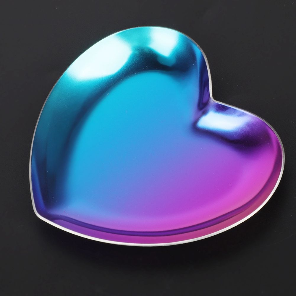 Colorful stainless steel heart-shaped tray used as a jewelry organizer, ideal for baby nursery or feeding accessories.