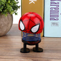 Cartoon doll head wobble toy ornament on ride-on car, featuring a shaking head design, for kids' play and car decoration.