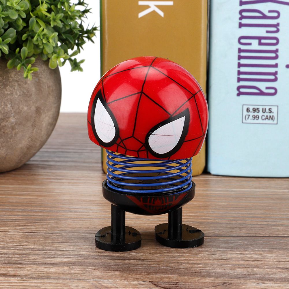 Cartoon doll head wobble toy ornament on ride-on car, featuring a shaking head design, for kids' play and car decoration.
