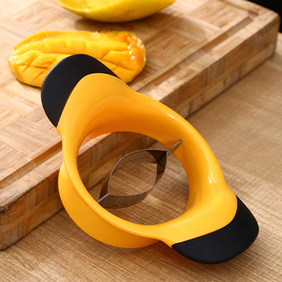 Two stainless steel mango slicer and peeler tools with ergonomic rubber grips, designed for easy fruit splitting and pitting.