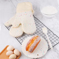 Set of 2 waterproof silicone oven mitts with cotton lining, ideal for baking and cooking, in a candy white color.