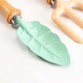 Leaf-shaped garden tools set with wooden handles, shovel and rake for kids, ideal for outdoor play in sand, yard, or sandbox.