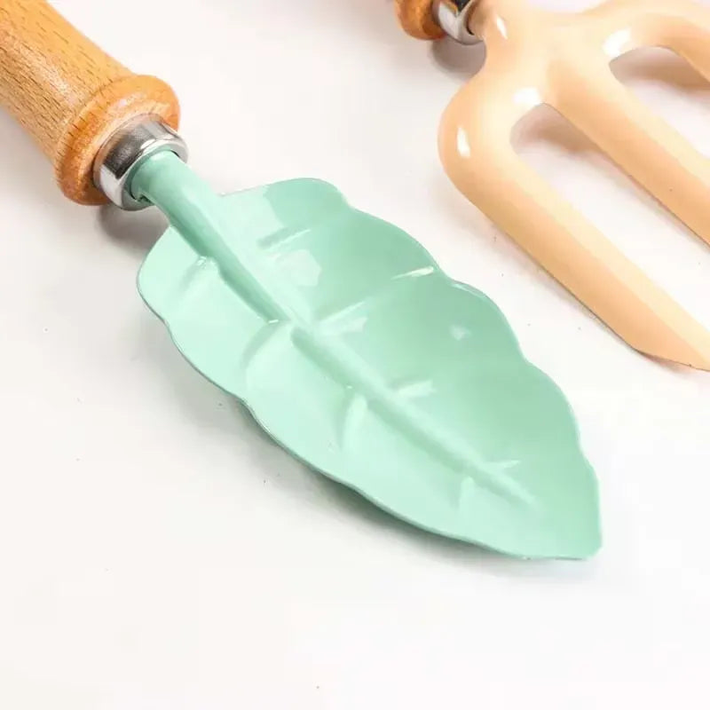 Leaf-shaped garden tools set with wooden handles, shovel and rake for kids, ideal for outdoor play in sand, yard, or sandbox.
