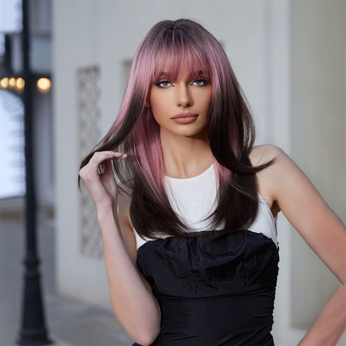 Long layered black and pink synthetic wig with bangs for women, featuring straight, shoulder-length hair and heat-friendly fibers.