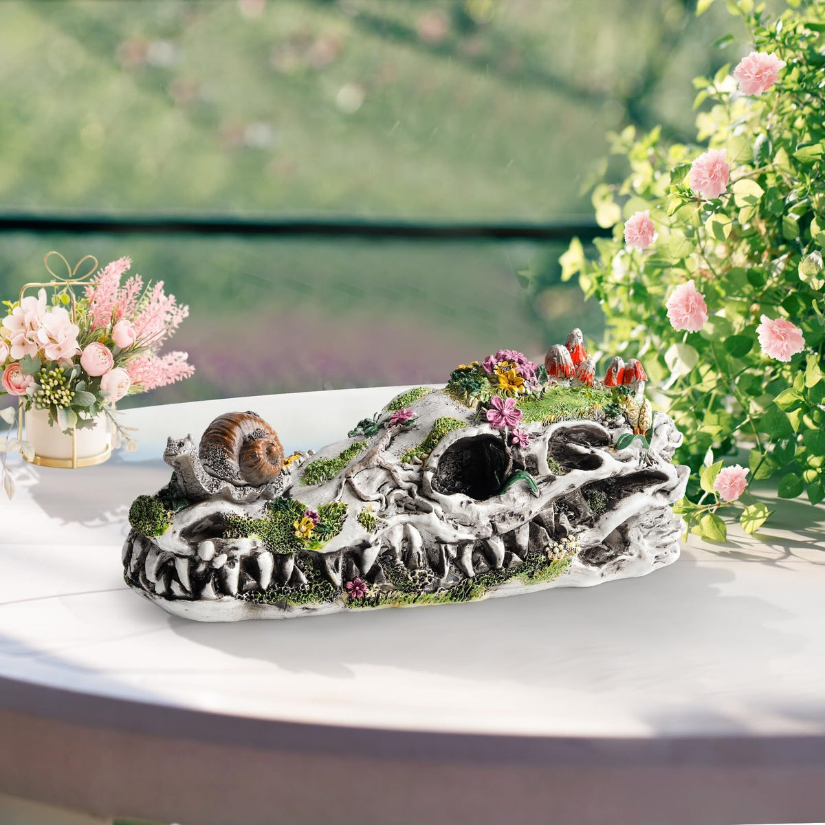 Resin dinosaur skull garden statue with snails and plants, outdoor decor for eco-friendly gardens, by Everything Baby.