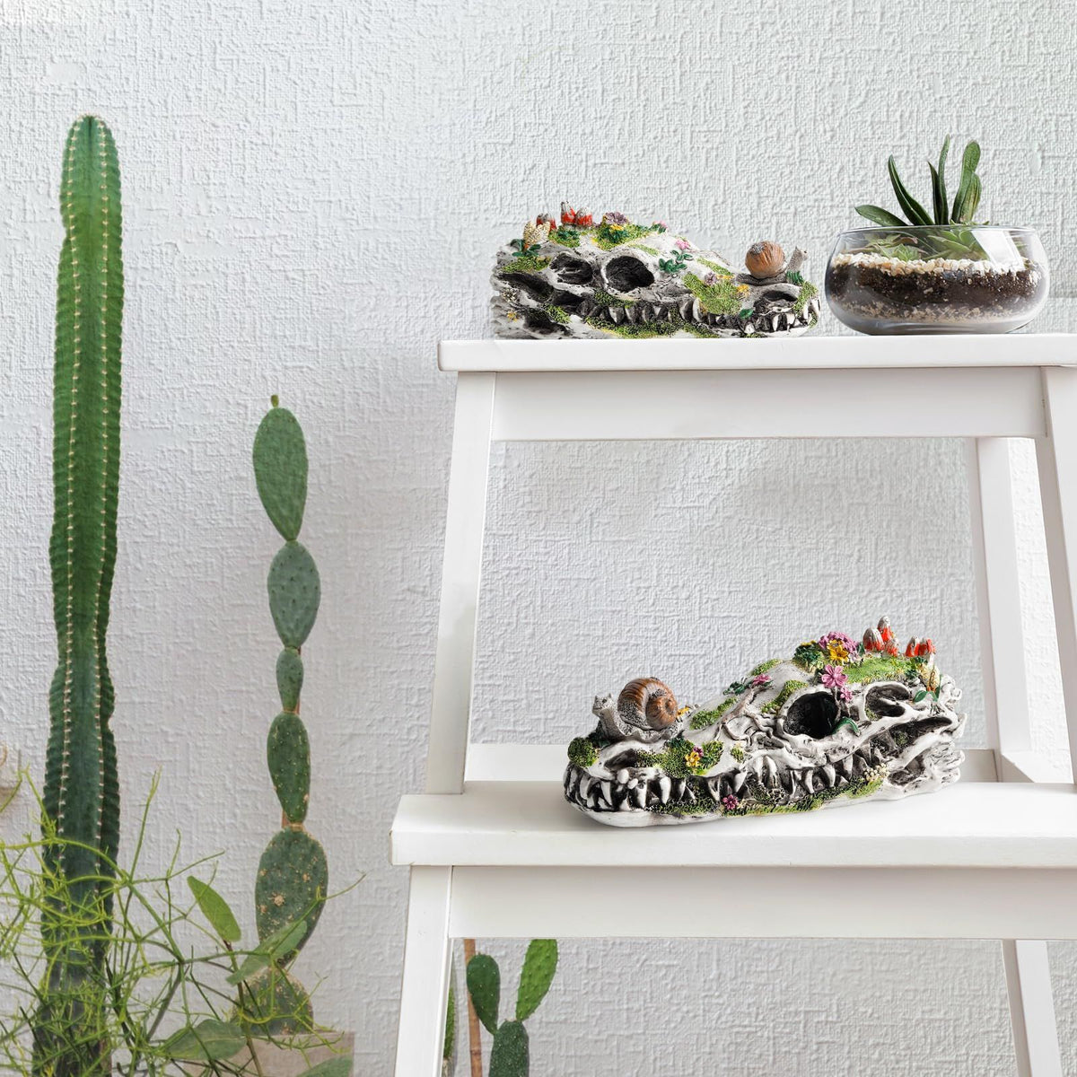 Dinosaur skull garden statue with snails and plants, eco-friendly resin outdoor decor for gardens and outdoor play areas.