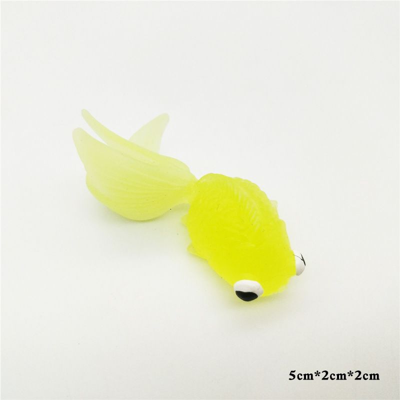 Colorful plastic fake goldfish swimming in a clear aquarium, realistic artificial moving fish toy for kids and aquarium decor.