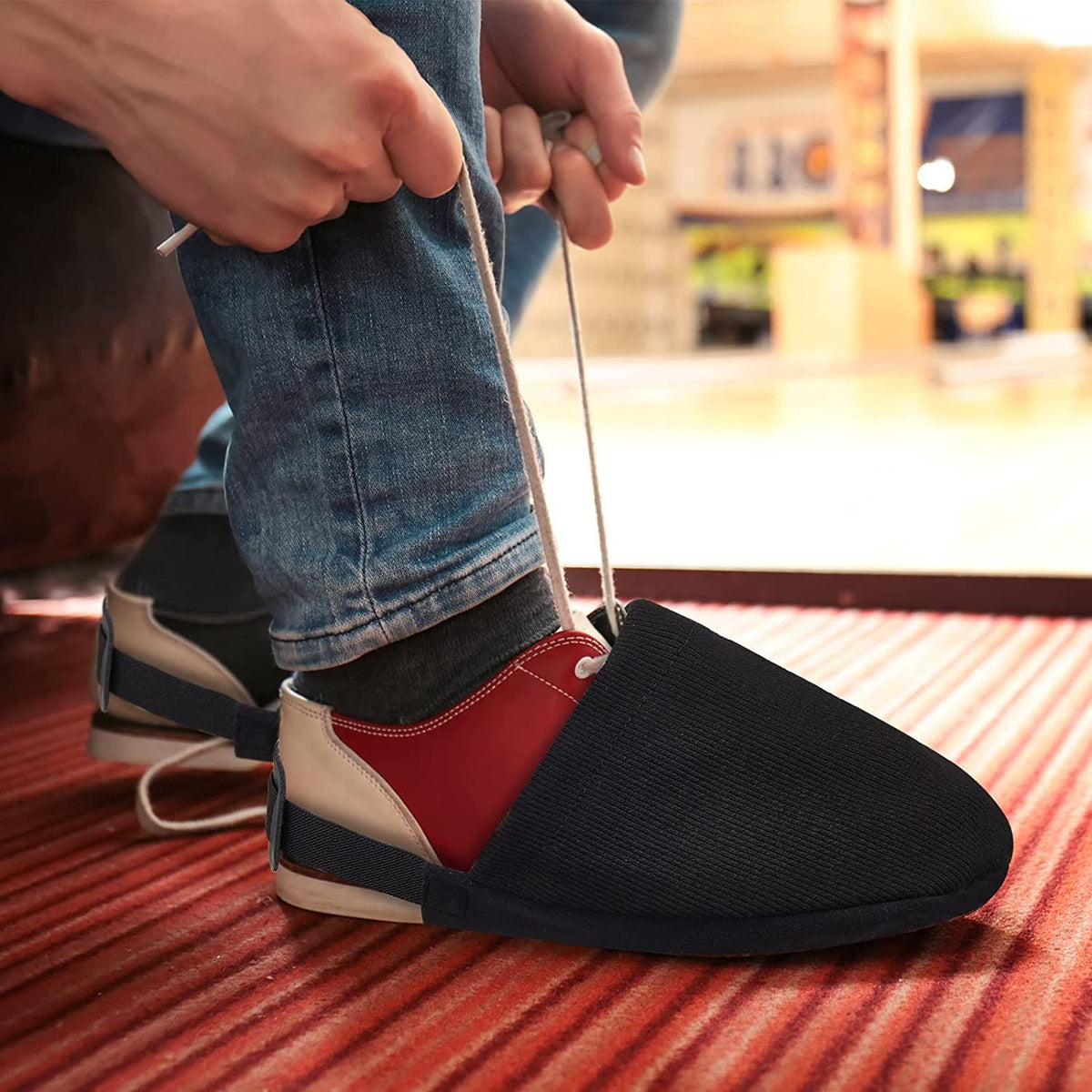 Pair of black bowling shoe covers from Everything Baby, designed for boys, with adjustable sliders for protection and easy fit.