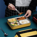 Stainless steel bento lunch box with four compartments, insulated bag, and cutlery, suitable for adults and work.