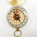 Gold brass pocket compass for camping and hiking, outdoor navigation tool, suitable for wilderness backpacking and survival activities.