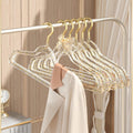 Set of 10 clear plastic hangers with gold glitter non-slip coating, ideal for baby boy's sleepwear and clothing storage.