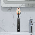 Beige silicone suction cup toothbrush holder for babies and kids, designed for bathroom use, from Everything Baby.